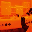 Waferbearbeitung im Reinraum. Orangefarbenes Licht wird eingesetzt, um eine...