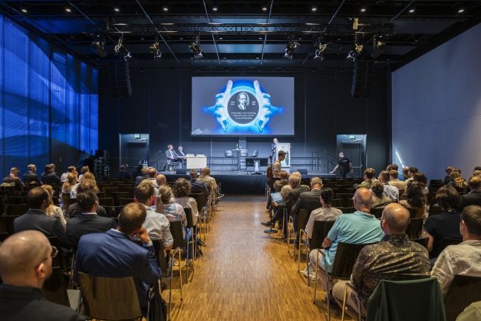 Zuhörerinnen und Zuhörer
verfolgen Krestins Vortrag...